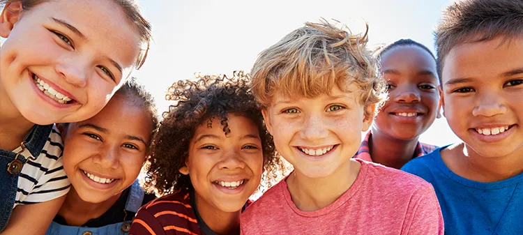 Small group of kids smiling in the sunlight