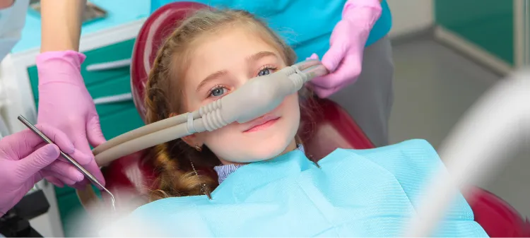 Young girl in the dental chair with a nitrous oxide mask on her nose