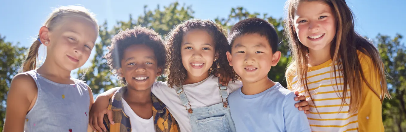 Five kids smiling together outdoors